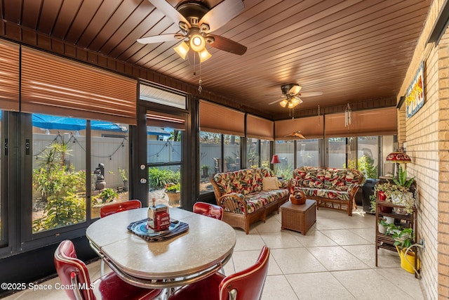 sunroom / solarium featuring a ceiling fan, wood ceiling, and plenty of natural light