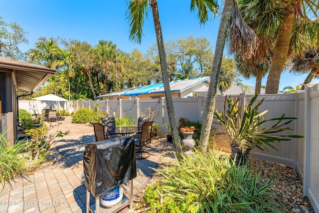 view of patio with outdoor dining area and a fenced backyard