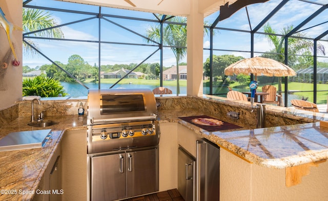 view of patio / terrace featuring a water view, grilling area, area for grilling, glass enclosure, and a sink