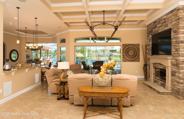 living area featuring a notable chandelier, a fireplace, coffered ceiling, ornamental molding, and beam ceiling