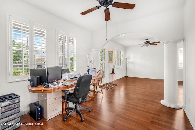 office space featuring a wealth of natural light, arched walkways, wood finished floors, and ornate columns