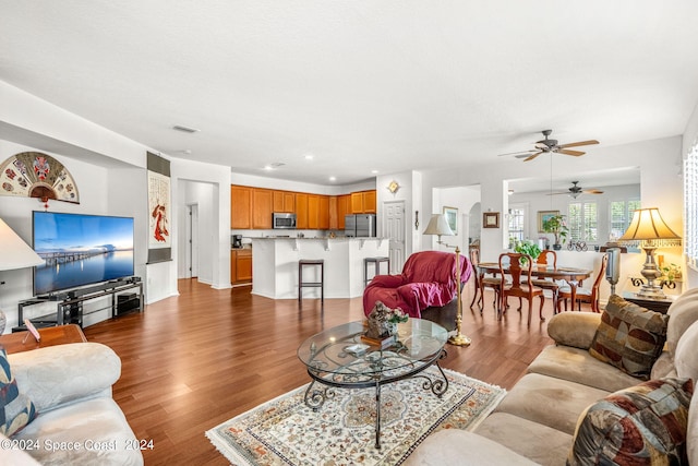 living room with wood finished floors, visible vents, and recessed lighting