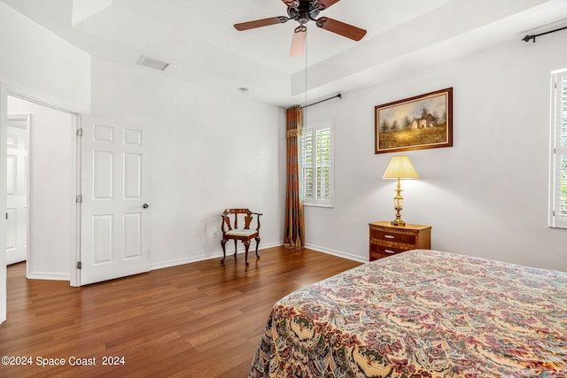 bedroom with wood finished floors, visible vents, and baseboards