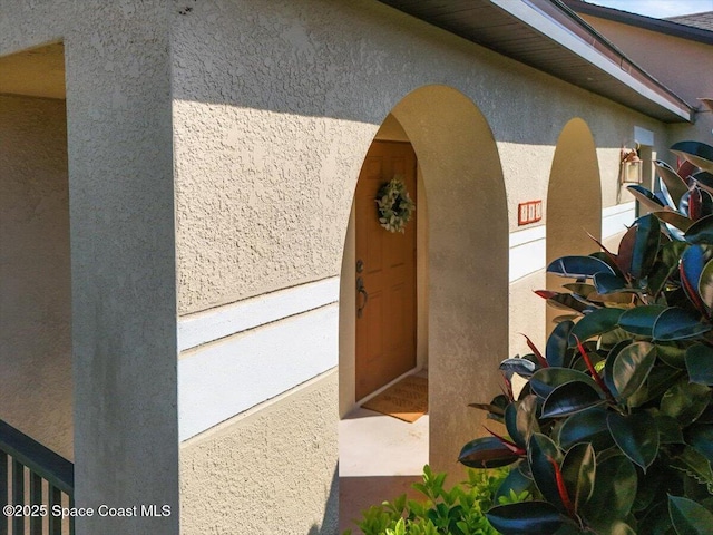 view of exterior entry featuring stucco siding