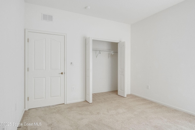 unfurnished bedroom featuring carpet floors, a closet, visible vents, and baseboards