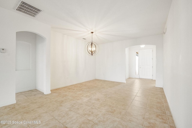 unfurnished room featuring an inviting chandelier, visible vents, and arched walkways