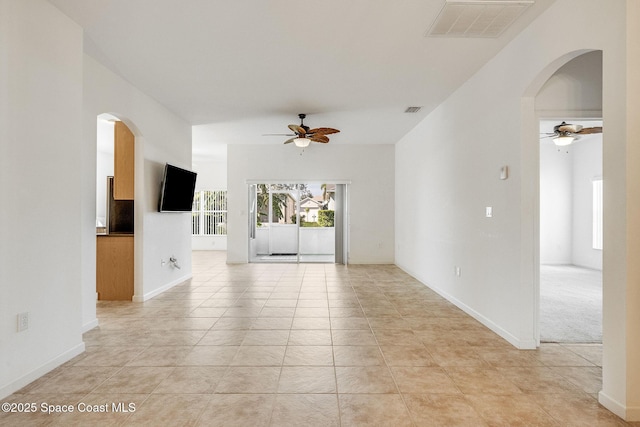 spare room with a ceiling fan, arched walkways, and visible vents