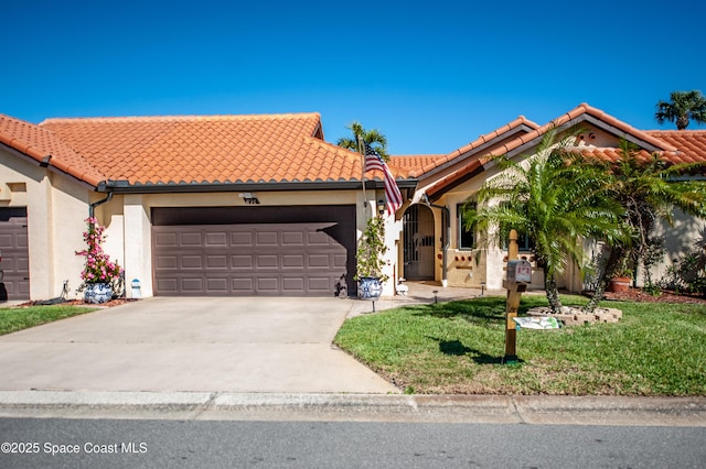 view of front of property with a front yard, driveway, an attached garage, stucco siding, and a tile roof