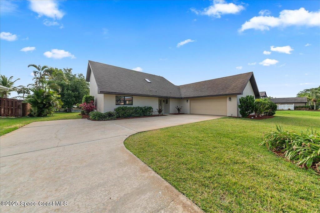 single story home featuring fence, driveway, a garage, stucco siding, and a front lawn