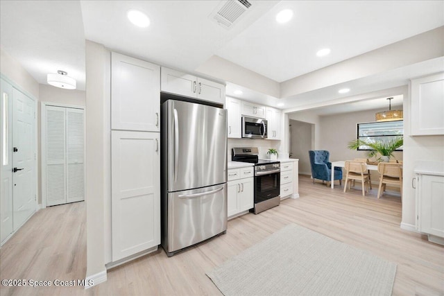 6315 Anchor Ln, Rockledge, FL 32955 - kitchen with appliances with stainless steel finishes, white cabinets, light wood-style flooring, and recessed lighting