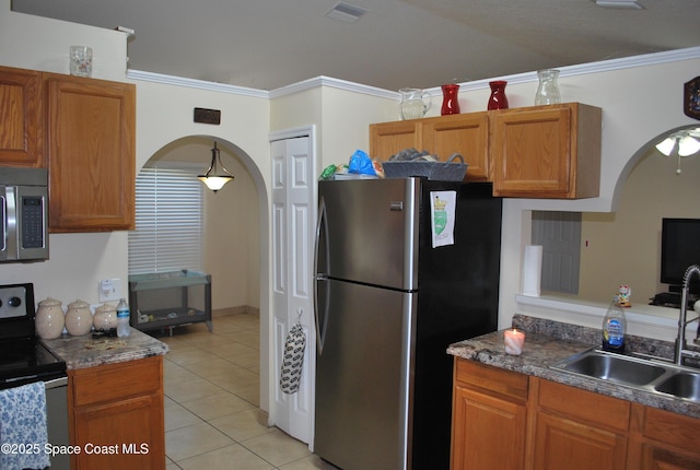 kitchen with appliances with stainless steel finishes, visible vents, a sink, and ornamental molding