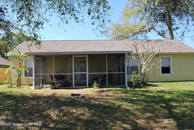 rear view of property with a sunroom, a shingled roof, fence, and a lawn