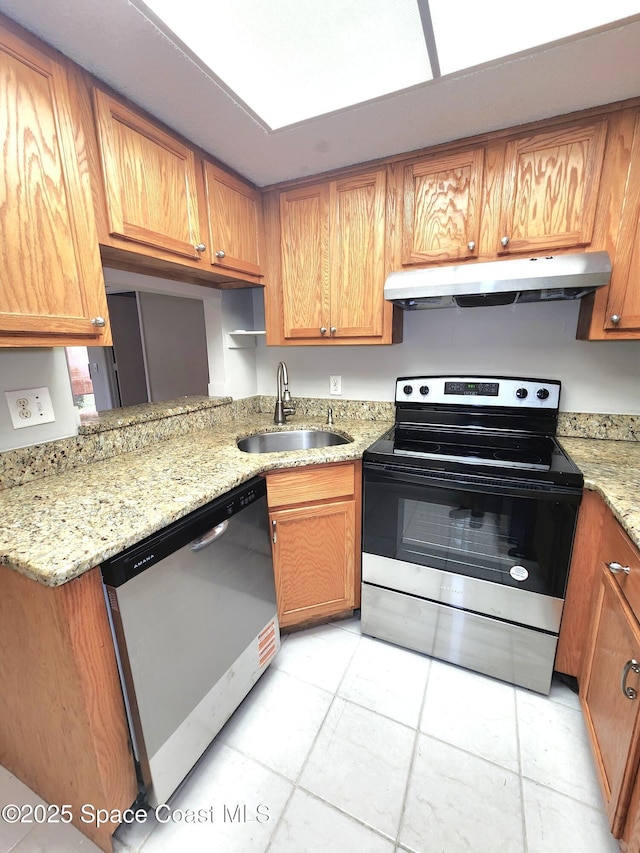 kitchen with appliances with stainless steel finishes, brown cabinets, light stone counters, under cabinet range hood, and a sink