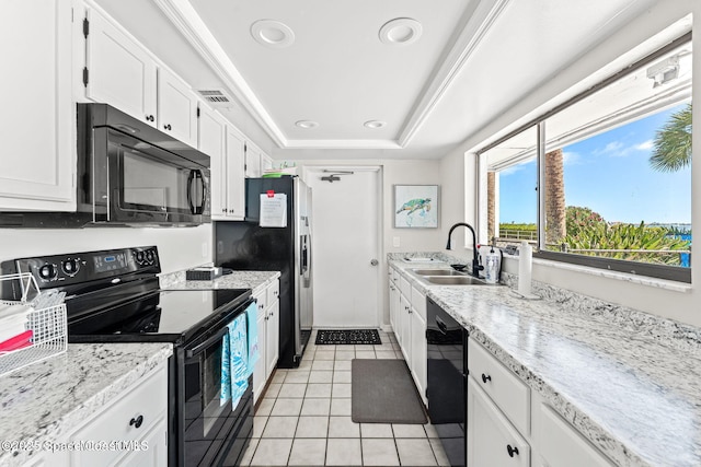 kitchen featuring visible vents, white cabinets, a raised ceiling, black appliances, and a sink