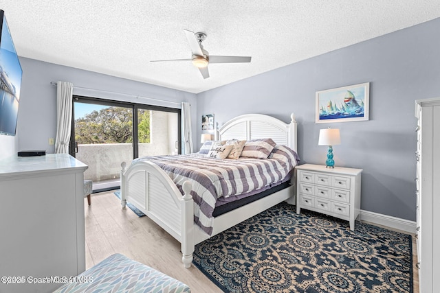 bedroom with light wood finished floors, baseboards, a ceiling fan, access to outside, and a textured ceiling