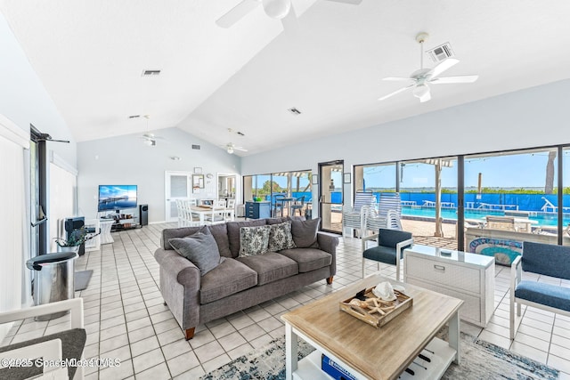 living room featuring ceiling fan, light tile patterned flooring, lofted ceiling, and visible vents