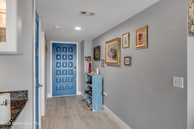 5055 Dixie Hwy NE Unit B206, Palm Bay, FL 32905 - corridor featuring light wood-style floors, a textured ceiling, and baseboards