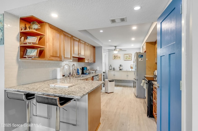 5055 Dixie Hwy NE Unit B206, Palm Bay, FL 32905 - kitchen with a sink, stainless steel appliances, light wood-style flooring, a ceiling fan, and tasteful backsplash