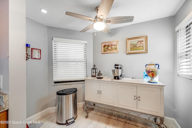 5055 Dixie Hwy NE Unit B206, Palm Bay, FL 32905 - kitchen featuring a ceiling fan, light wood-style flooring, baseboards, light countertops, and a textured ceiling