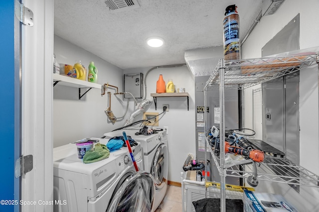 5055 Dixie Hwy NE Unit B206, Palm Bay, FL 32905 - washroom featuring washing machine and dryer, a textured ceiling, baseboards, and light tile patterned floors