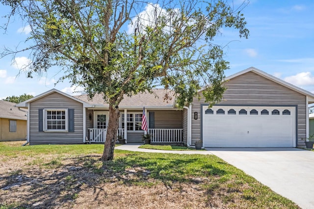 single story home featuring an attached garage, a front lawn, a porch, and concrete driveway