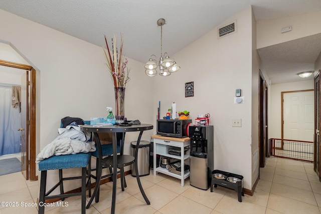 dining space featuring lofted ceiling, visible vents, a notable chandelier, and light tile patterned flooring