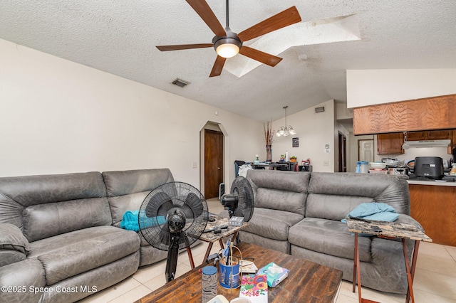 living area featuring lofted ceiling, ceiling fan, light tile patterned floors, arched walkways, and visible vents