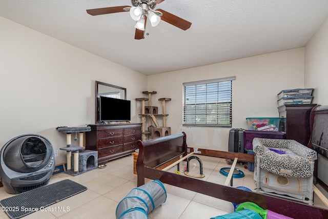 bedroom featuring a textured ceiling, tile patterned flooring, and a ceiling fan