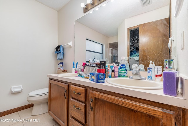 bathroom with toilet, a sink, visible vents, tile patterned floors, and double vanity