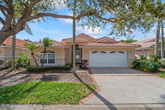 view of front of property with a garage, concrete driveway, a tile roof, and stucco siding