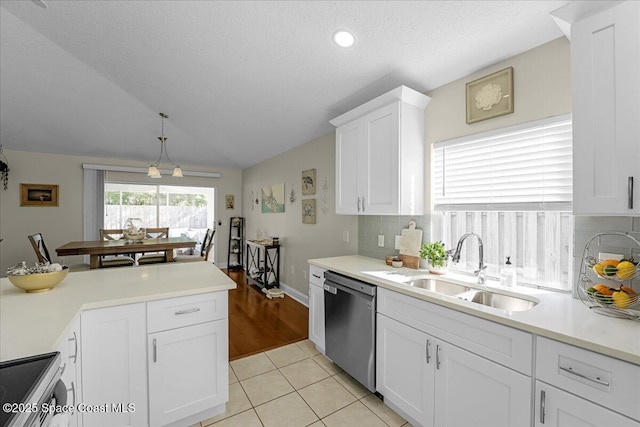 kitchen featuring light tile patterned floors, a sink, stainless steel appliances, light countertops, and white cabinetry