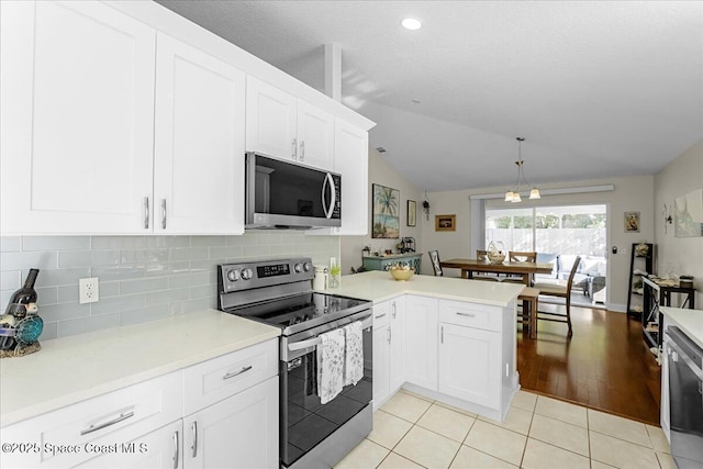 kitchen featuring tasteful backsplash, appliances with stainless steel finishes, light countertops, and a peninsula