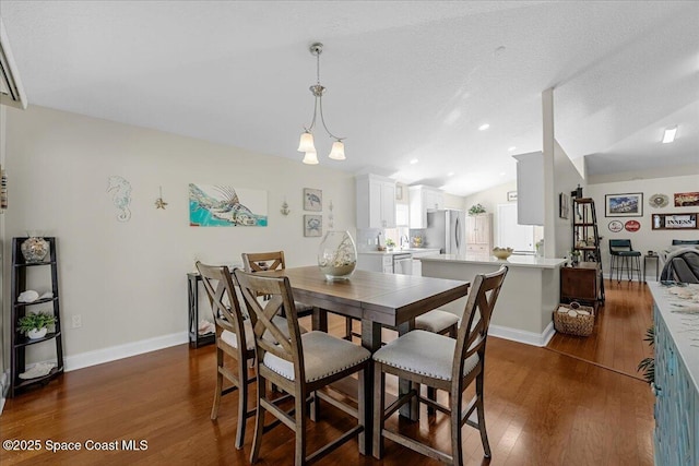 dining space featuring dark wood finished floors, vaulted ceiling, recessed lighting, and baseboards