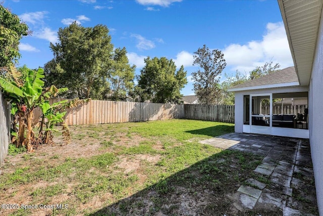 view of yard featuring a fenced backyard and a sunroom