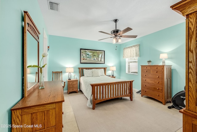 bedroom with ceiling fan, light tile patterned flooring, visible vents, and baseboards