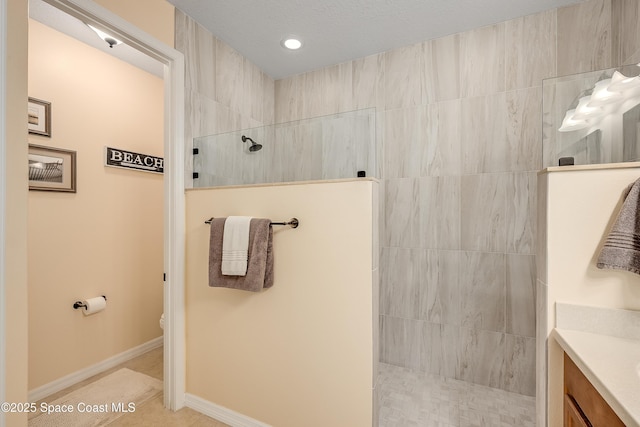 bathroom with toilet, vanity, walk in shower, baseboards, and tile patterned floors