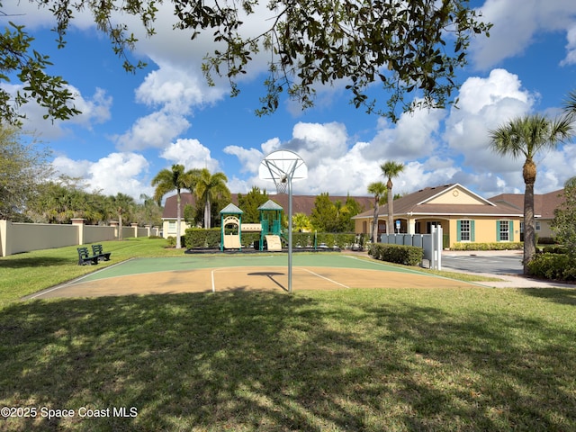 view of basketball court featuring fence, playground community, and a yard