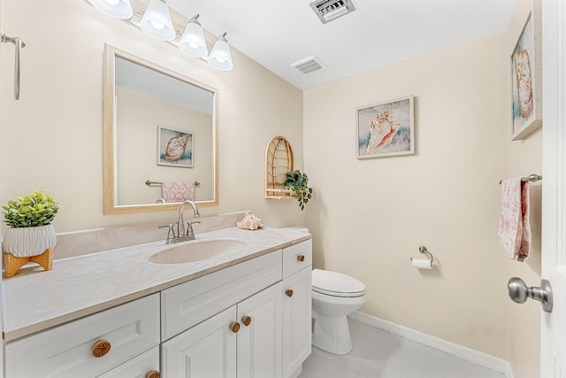 bathroom featuring toilet, vanity, visible vents, and baseboards