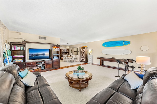 living room with carpet, visible vents, a textured ceiling, and baseboards