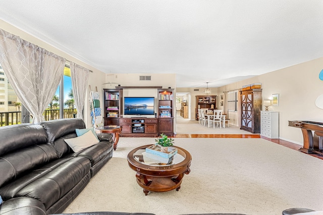 carpeted living area with visible vents and a textured ceiling