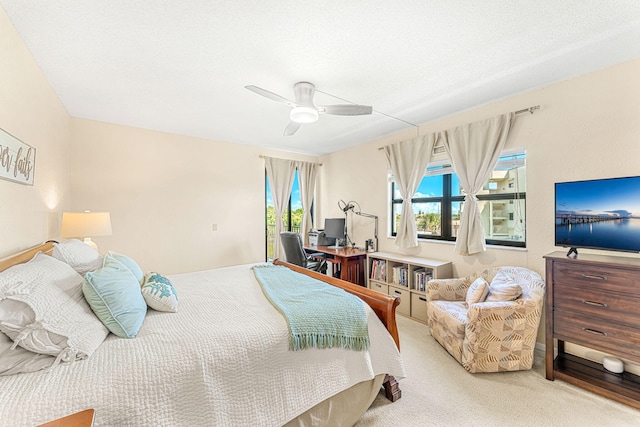 bedroom featuring a textured ceiling, access to outside, carpet flooring, and a ceiling fan