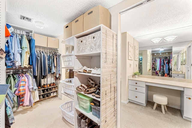 spacious closet featuring visible vents and light carpet