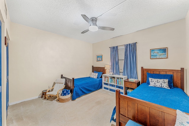 carpeted bedroom featuring ceiling fan, a textured ceiling, and baseboards