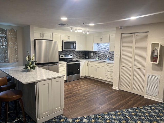 kitchen with stainless steel appliances, a sink, visible vents, and white cabinets