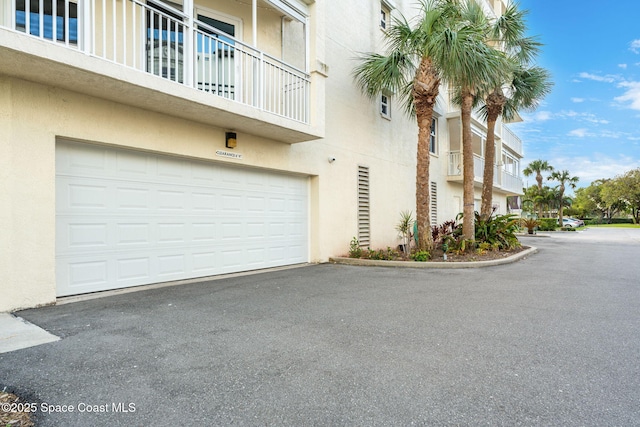 view of building exterior featuring driveway and an attached garage