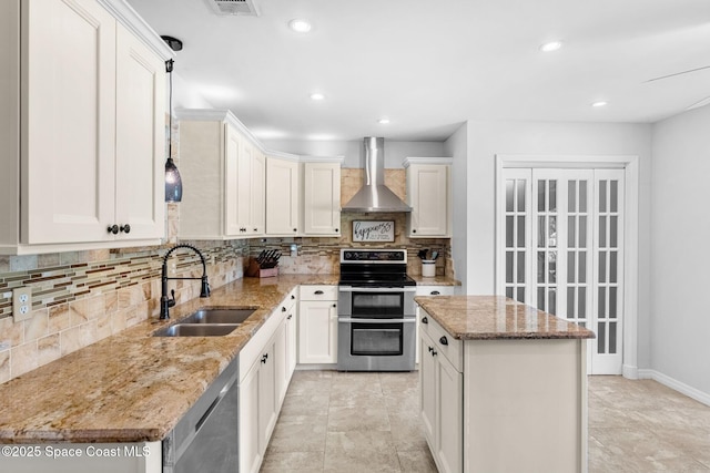 kitchen with wall chimney exhaust hood, tasteful backsplash, appliances with stainless steel finishes, light stone counters, and a sink