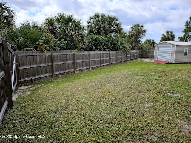 view of yard featuring an outbuilding, a fenced backyard, and a storage unit