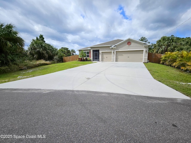 single story home with a front yard, fence, driveway, and an attached garage