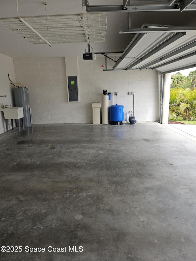 garage featuring a sink, electric panel, and a garage door opener