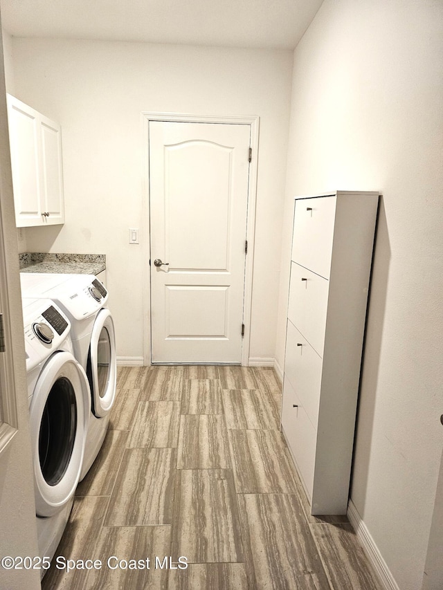 washroom with washer and clothes dryer, cabinet space, and baseboards